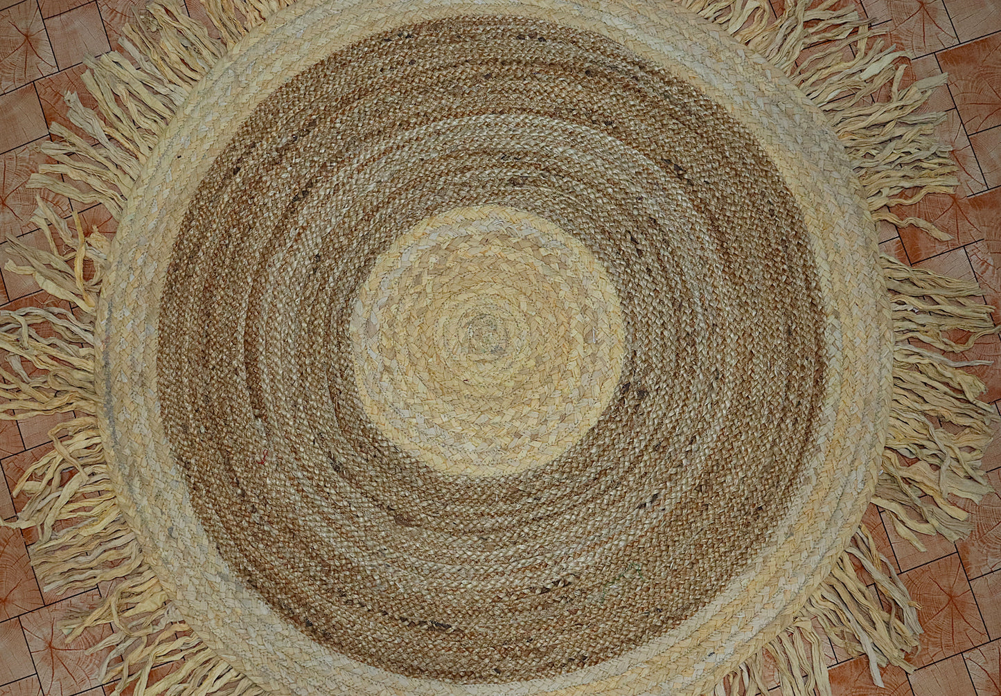 Round braided rug with fringes on a tiled floor
