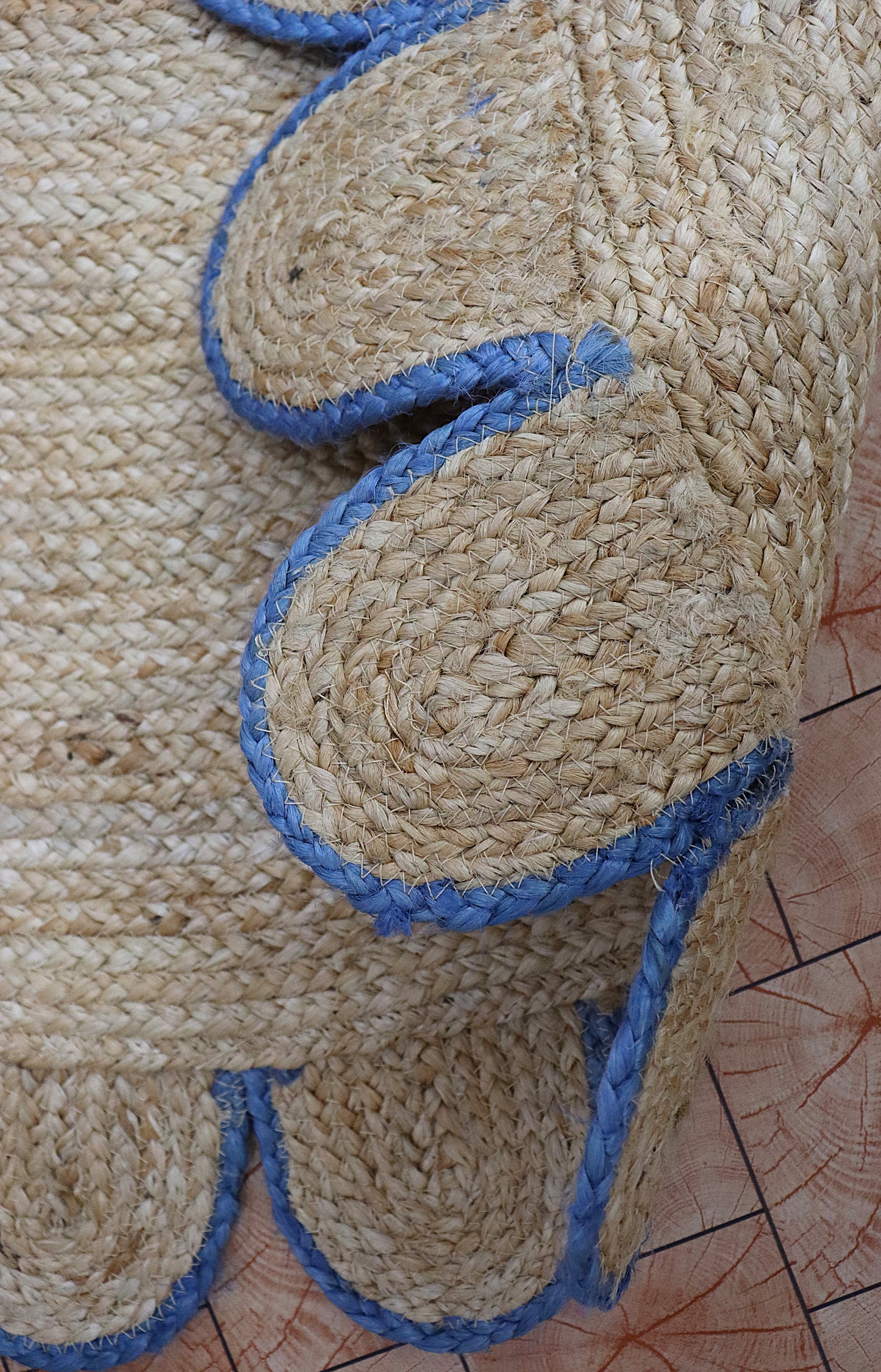 Close-up of a woven mat with blue accents on a wooden surface