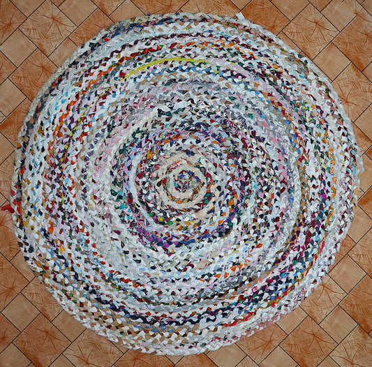 Round multicolored braided rug on a wooden floor