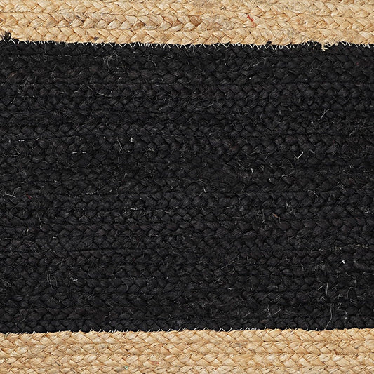 Close-up of a black and beige woven rug with natural fiber edges.