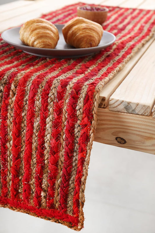 Red and beige woven table runner on a wooden table with pastries.
