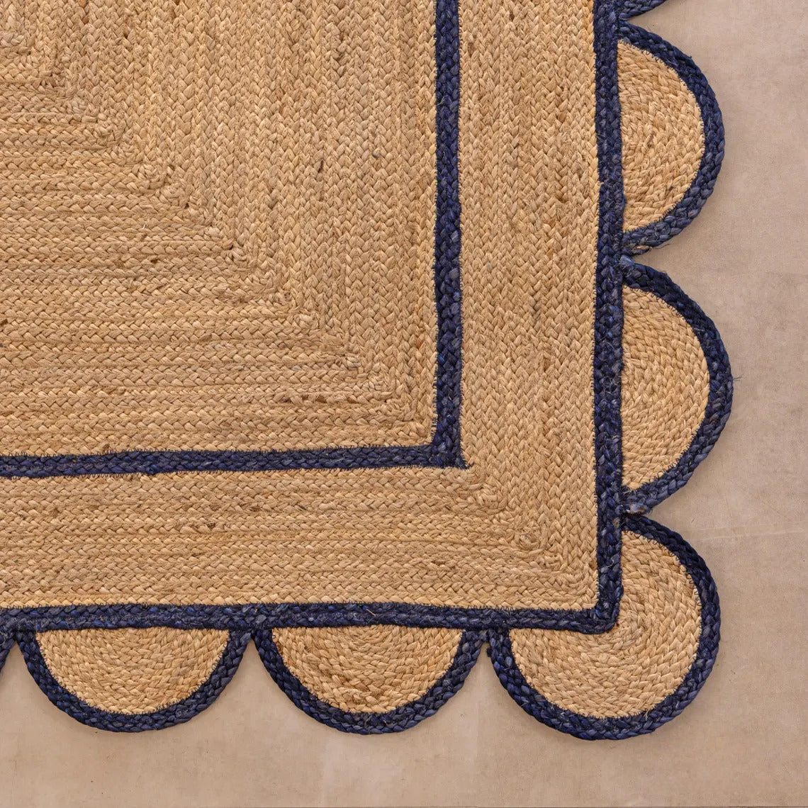 Beige rug with scalloped navy border on a beige background