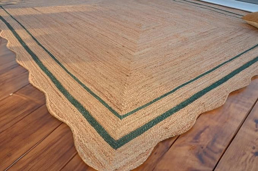 Beige woven mat with green border on a wooden floor