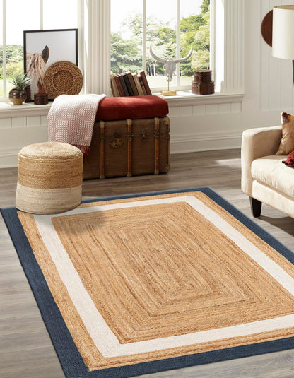 Natural jute area rug with beige and navy blue border, ideal for rustic home decor. Durable and stylish.