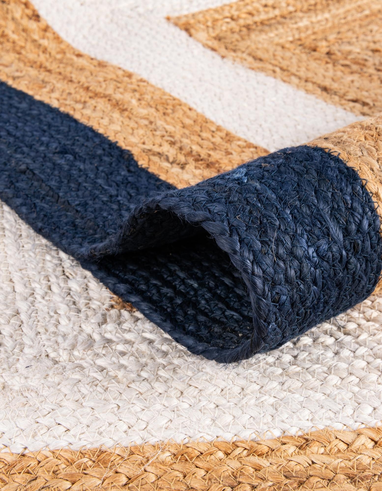 Navy blue woven jute rug with natural and cream stripes, perfect for eco-friendly decor.