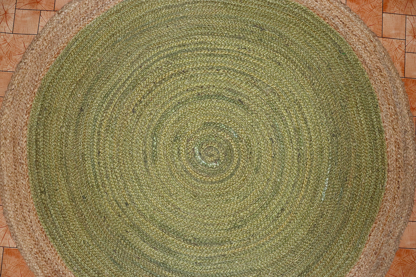 Round green braided rug on a tiled floor