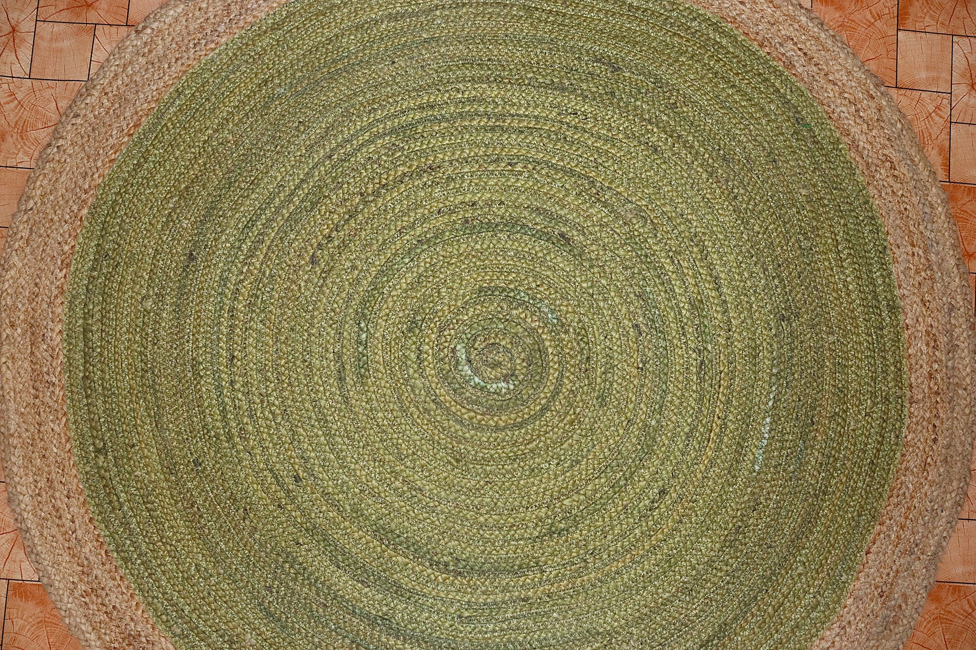 Round green braided rug on a tiled floor