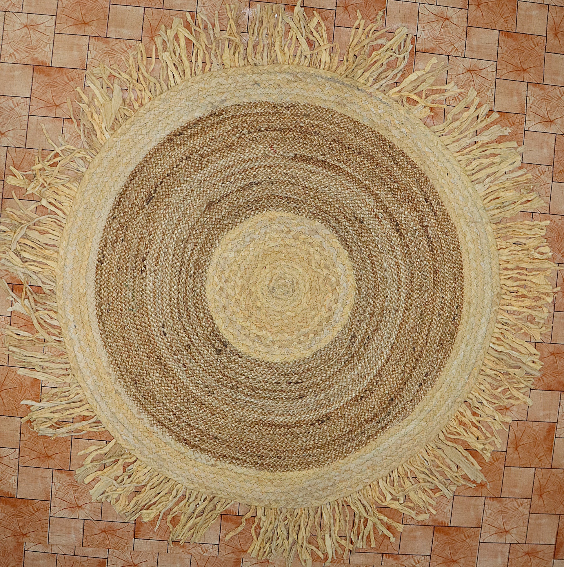 Round woven rug with fringes on a tiled floor