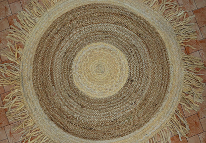Round braided rug with fringes on a tiled floor