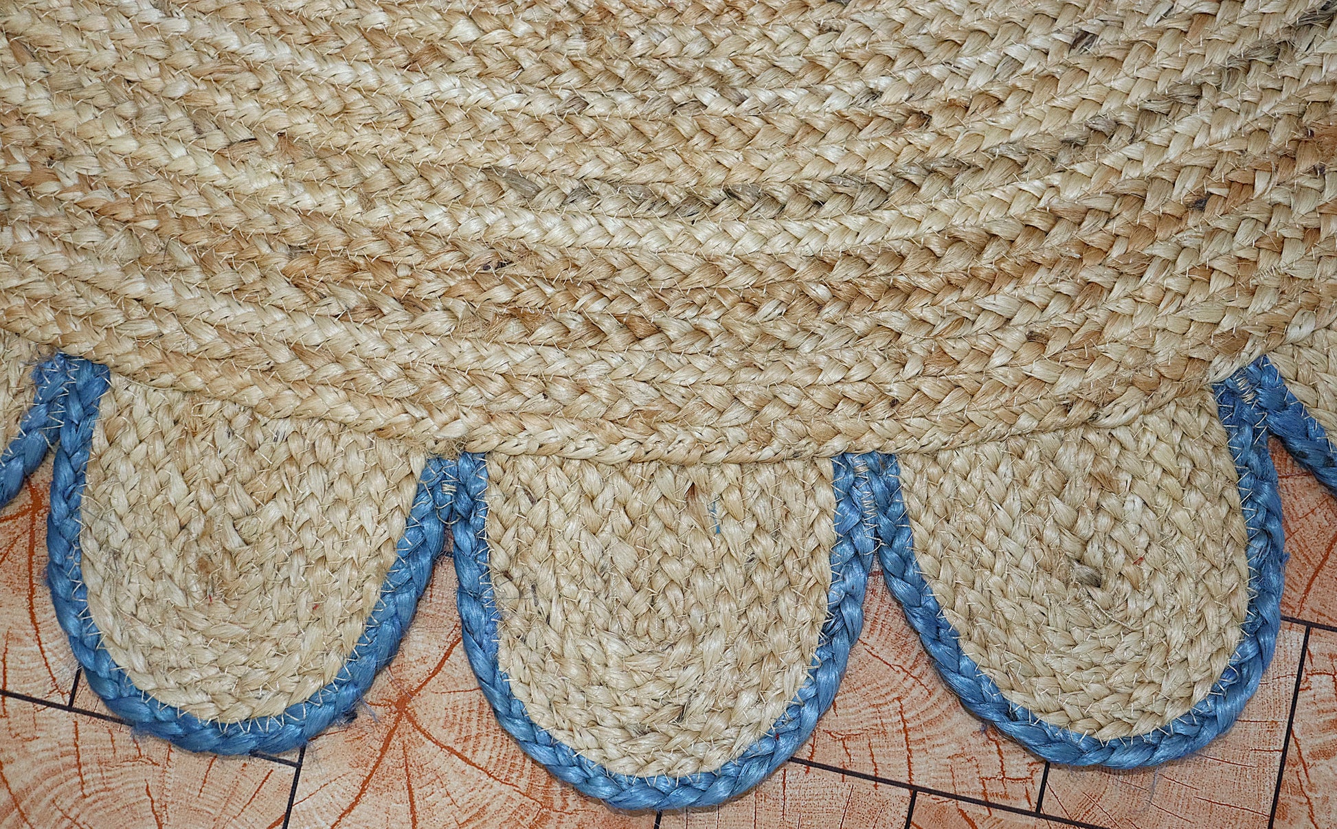 Textured woven mat with blue decorative elements on a wooden surface