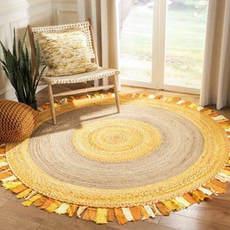 Round braided rug with multicolor pattern on wooden floor, chair with pillow in background