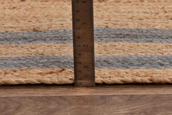 Natural jute rug with gray stripes, featuring a height measurement close-up.