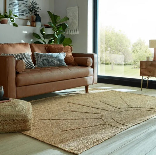 Natural jute area rug with sunburst design, perfect for enhancing a cozy living room space.