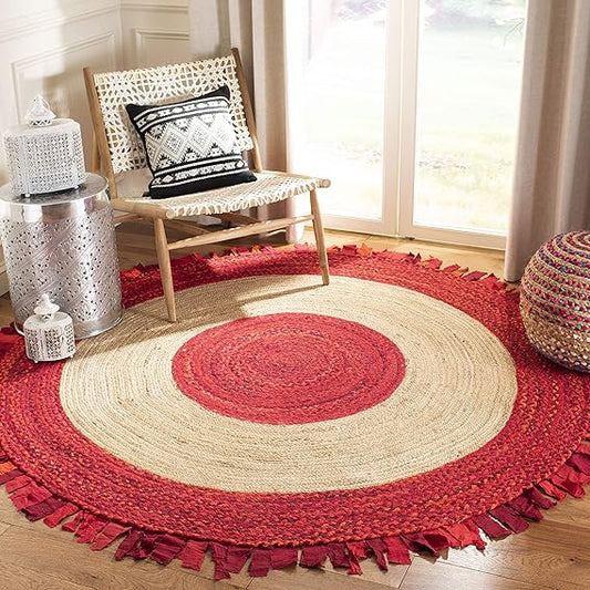 Round red and beige braided rug in a room with a chair and decorative items.