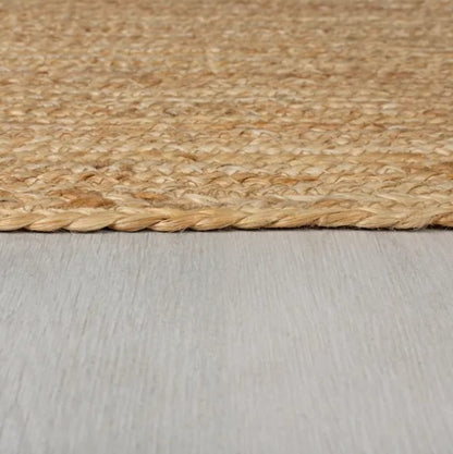 Natural jute area rug with braided edges, perfect for adding warmth to any space.