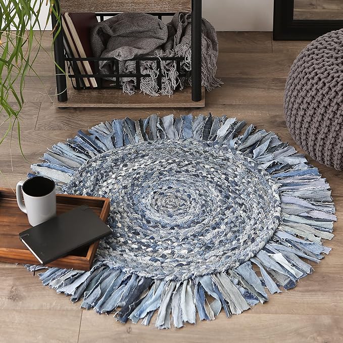 Round blue and gray braided rug with tassels on a wooden floor.