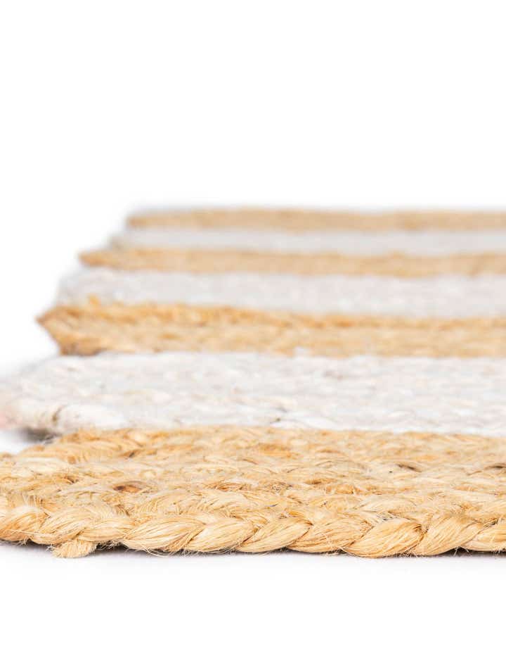 Close-up of a woven mat with beige and white stripes on a white background