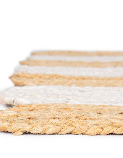 Close-up of a woven mat with beige and white stripes on a white background
