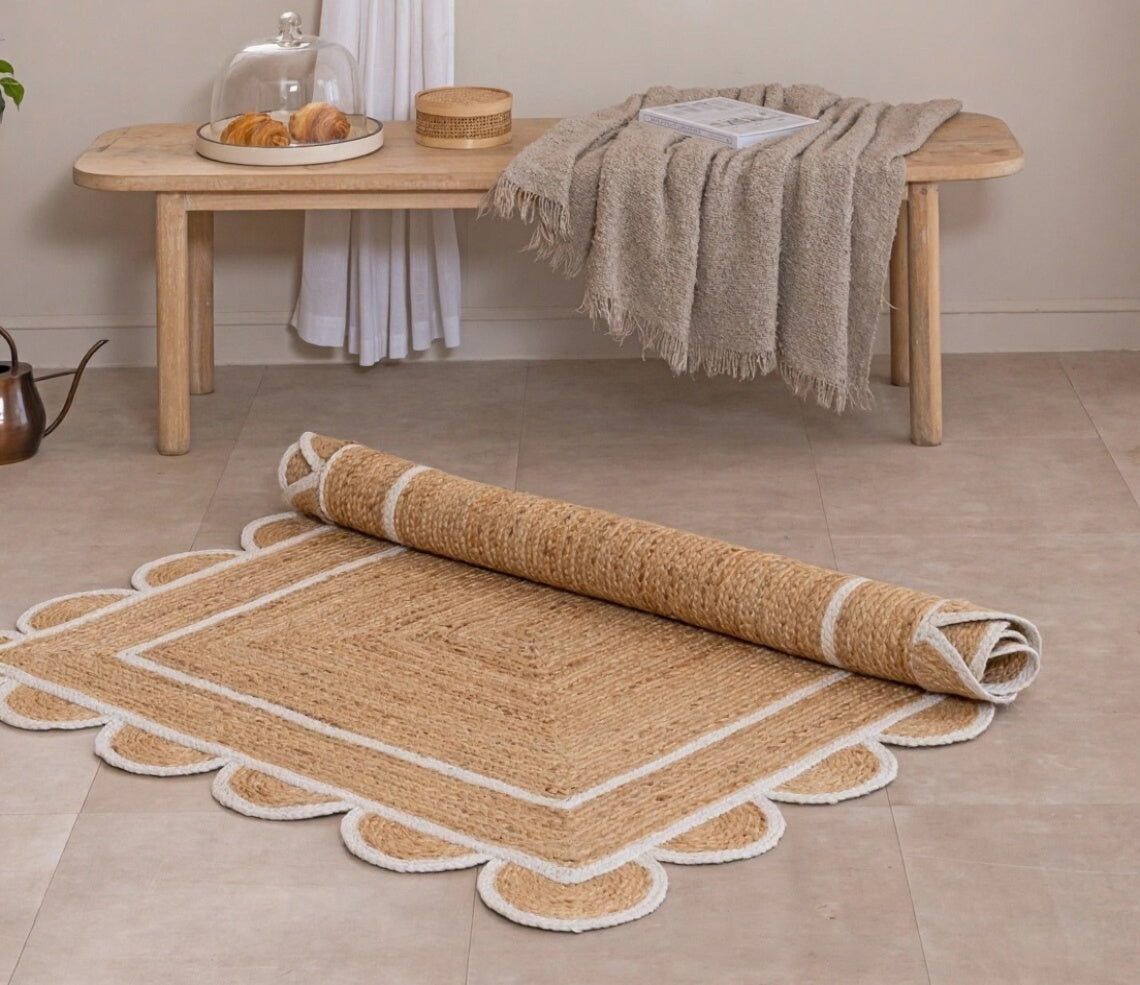 Rolled jute rug on a tiled floor with a wooden bench and table in the background.