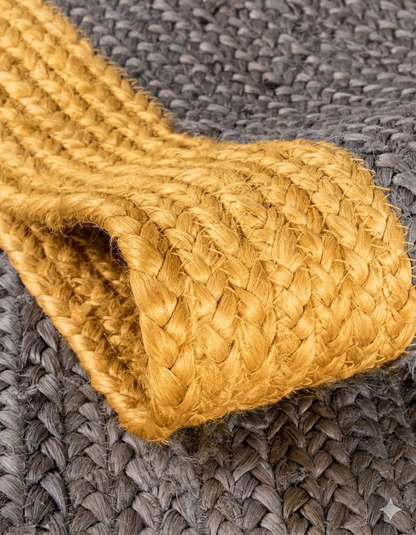 Close-up of a woven yellow mat on a textured gray surface