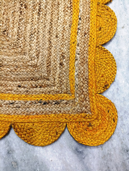 Jute rug with yellow scalloped edge on a marble surface