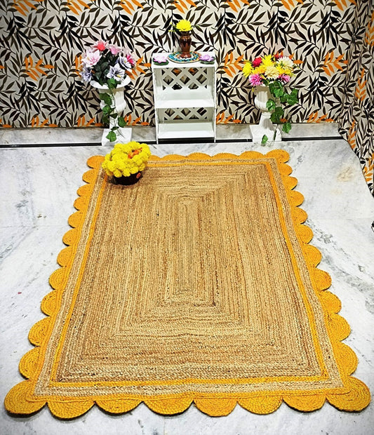 Jute rug with yellow scalloped edge on a marble floor, with decorative elements and patterned wall in the background.