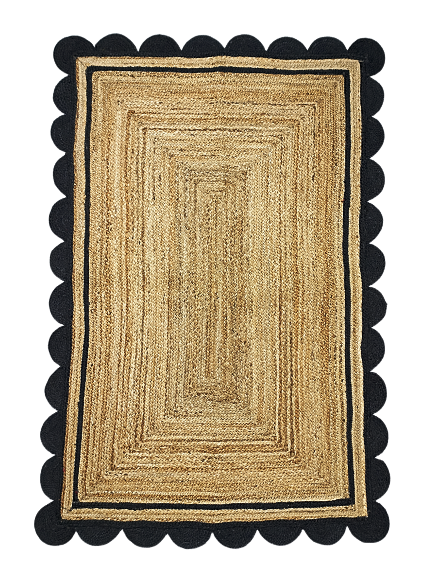 Beige braided rug with black scalloped border on a white background