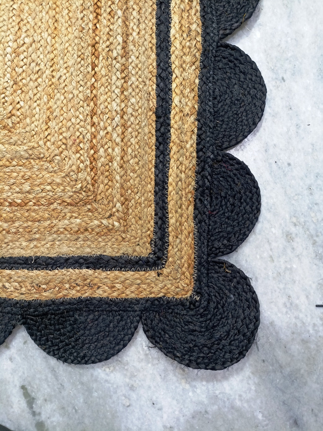 Textured doormat with scalloped edge on a light background