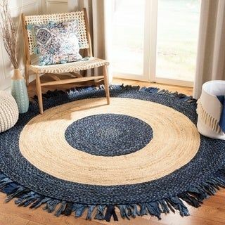 Round blue and beige braided rug with a chair and decorative items in a room.