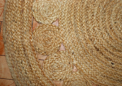 Close-up of a woven jute mat with spiral patterns on a wooden surface.