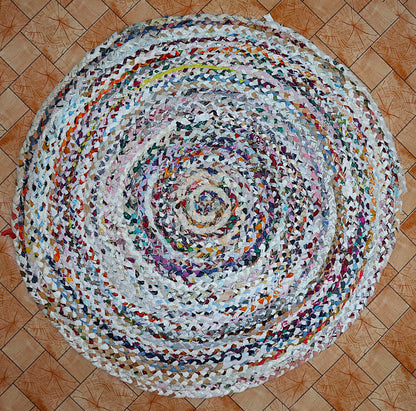 Round multicolored braided rug on a wooden floor