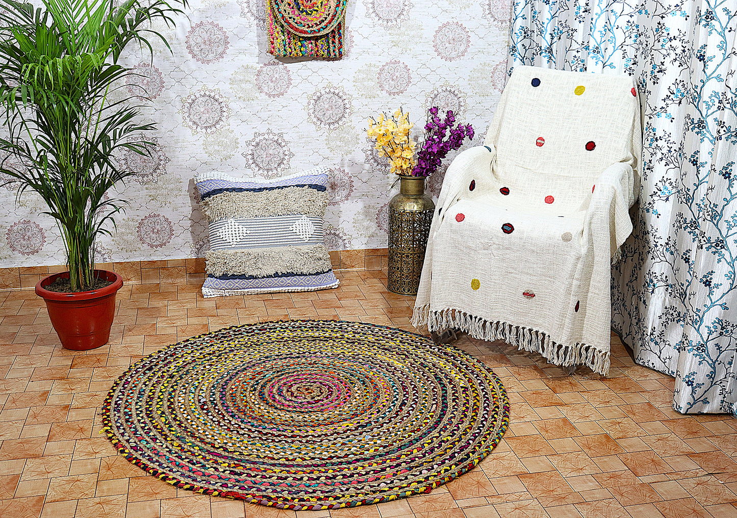 Round braided rug on a wooden floor with a patterned wall and decorative elements.