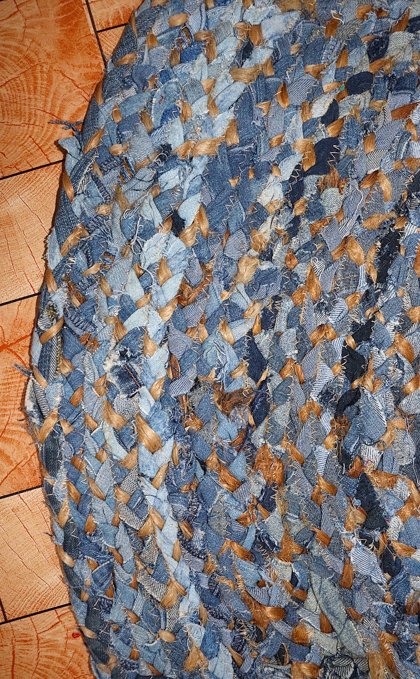 Blue and brown braided rug on a wooden floor