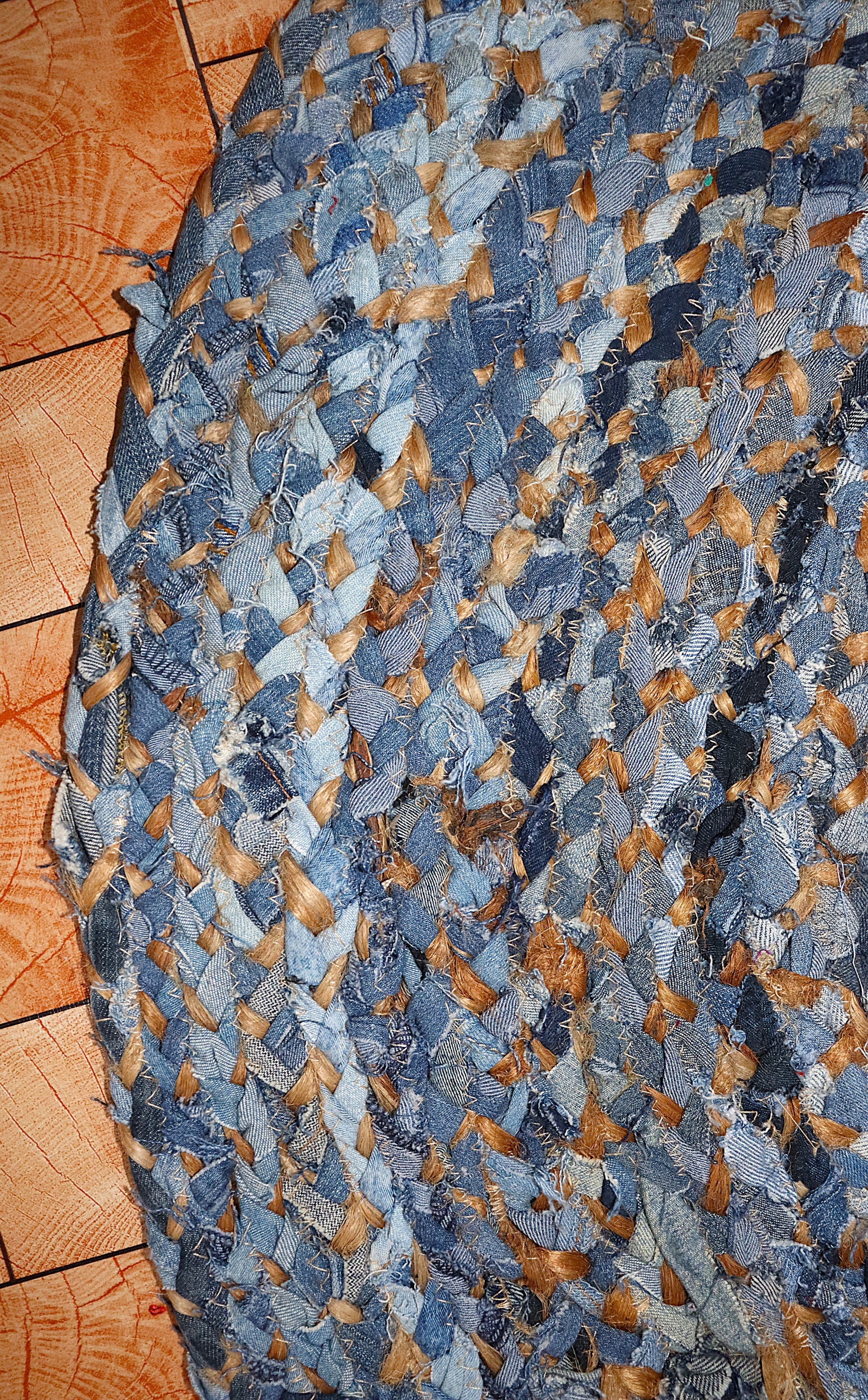 Blue and brown braided rug on a wooden floor