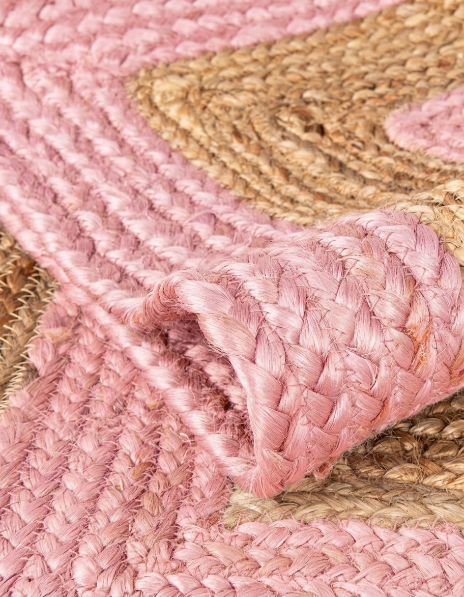 Natural Jute Area Rug pink braided jute floor carpet with woven texture and layered rug edge close-up