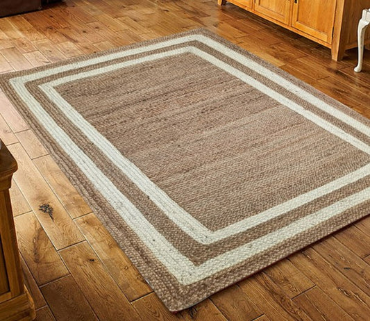 Brown area rug with white border on a wooden floor