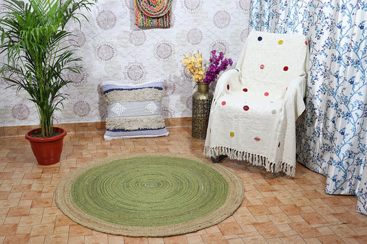 Room interior with a green circular rug, white chair with colorful polka dot blanket, and decorative elements.