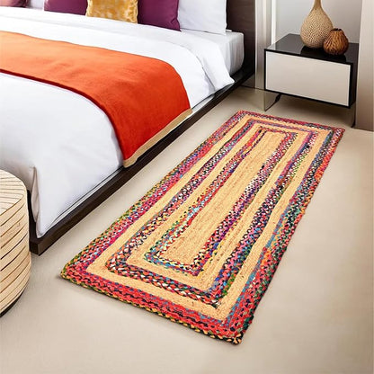 Colorful braided rug on a beige floor in a bedroom setting.