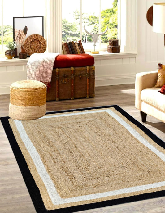 Beige area rug with black border in a living room setting