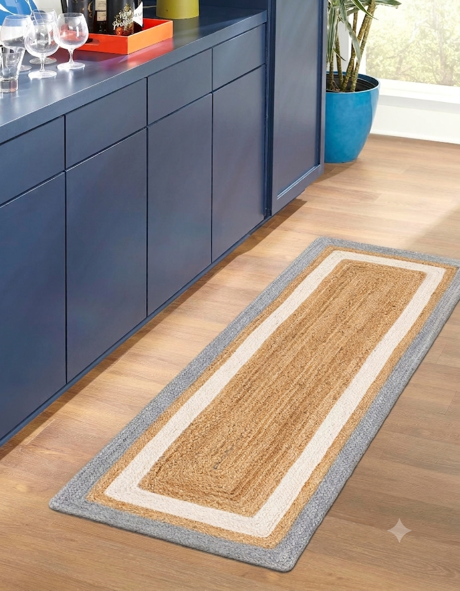 Long rectangular rug on a wooden floor in front of blue cabinets.