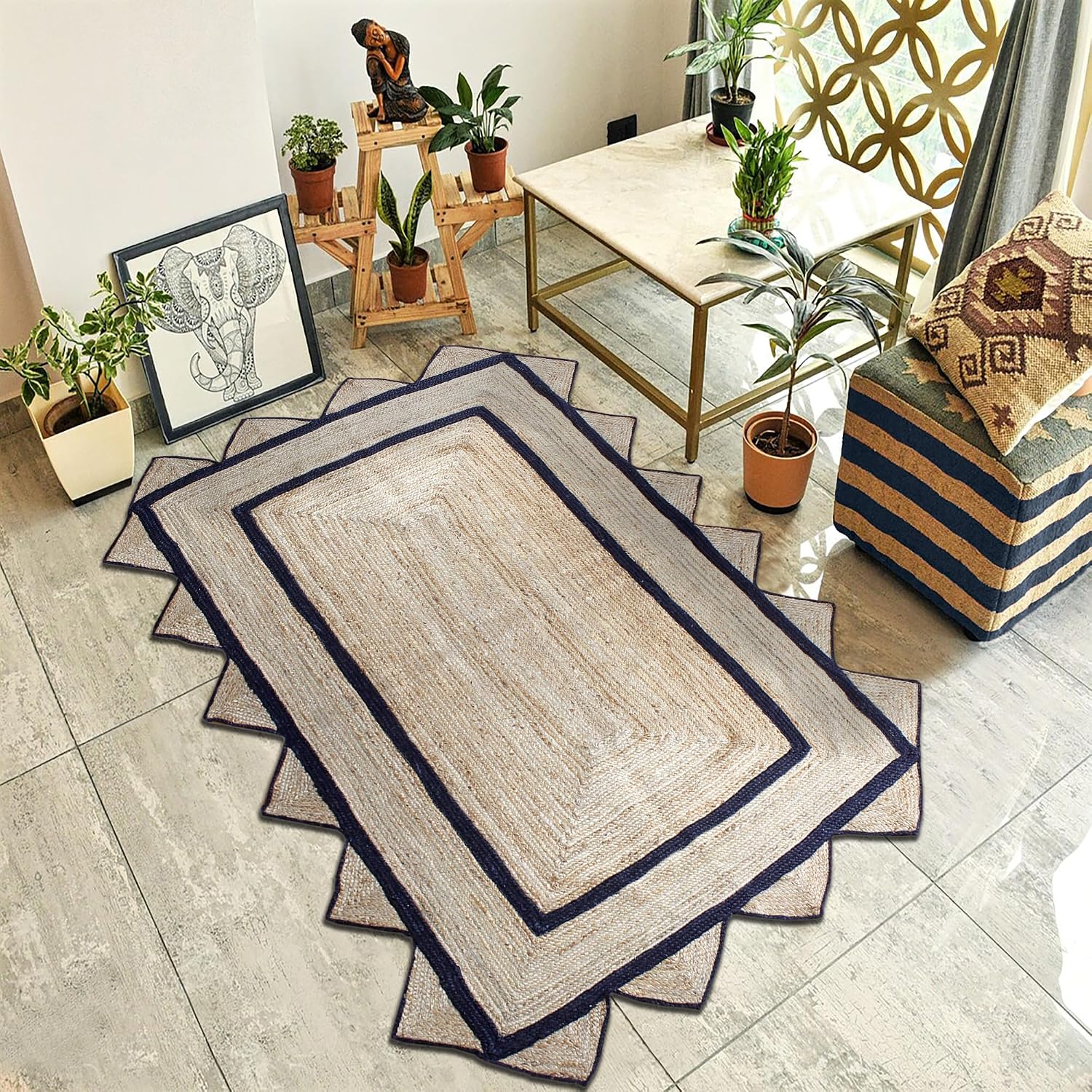 A rectangular woven area rug with a beige center and dark navy blue stitched borders, styled in a modern living room setting.
