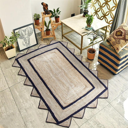 A rectangular woven area rug with a beige center and dark navy blue stitched borders, styled in a modern living room setting.