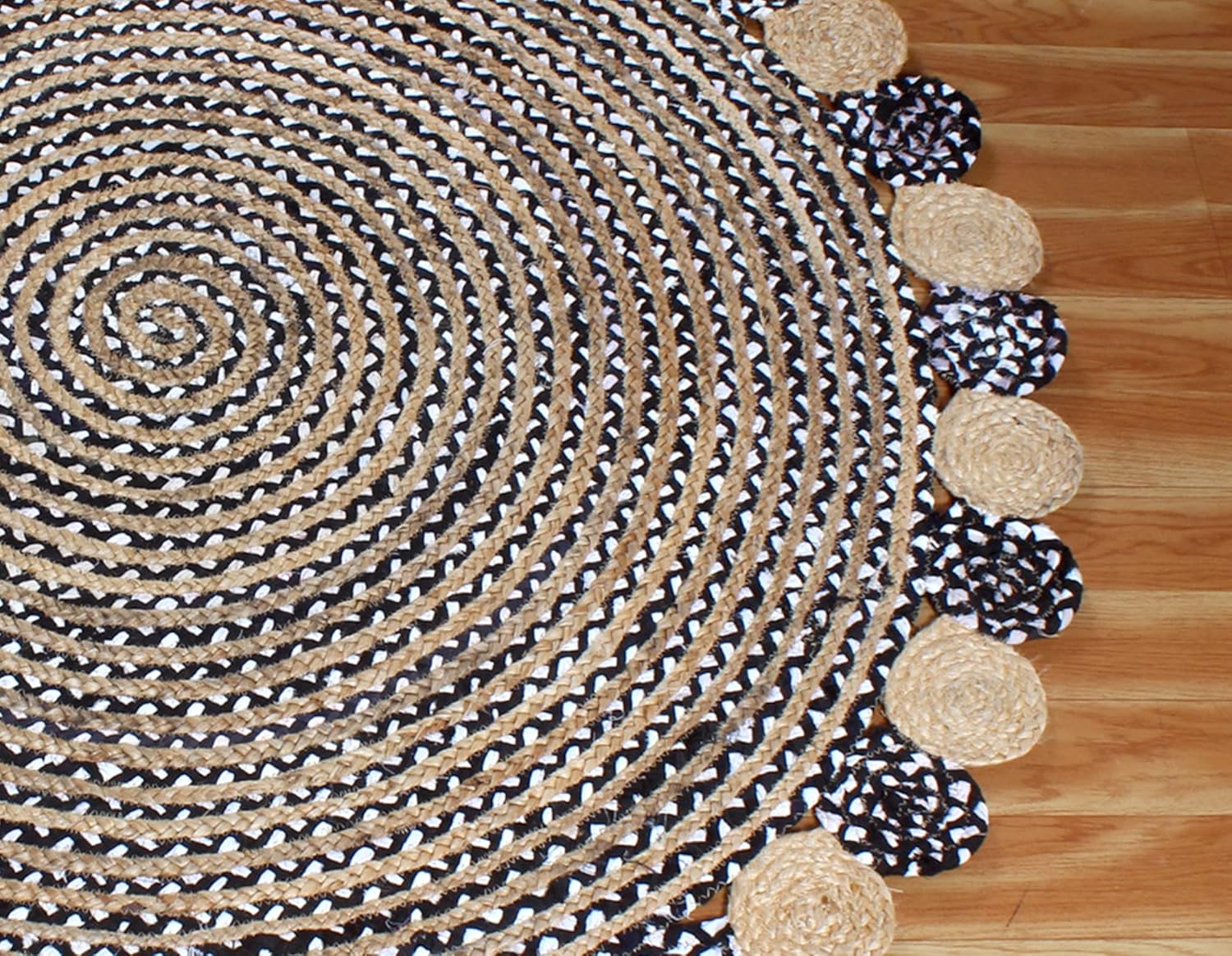 Round braided rug with a patterned border on a wooden floor