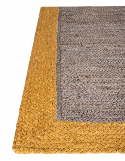 Gray and yellow braided rug corner on a white background