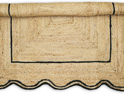 Natural Jute Area Rug with scalloped edges and black trim, suitable for indoor or outdoor use.