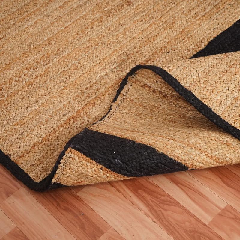 Natural Jute Area Rug with black border on wood floor, woven textured jute pattern