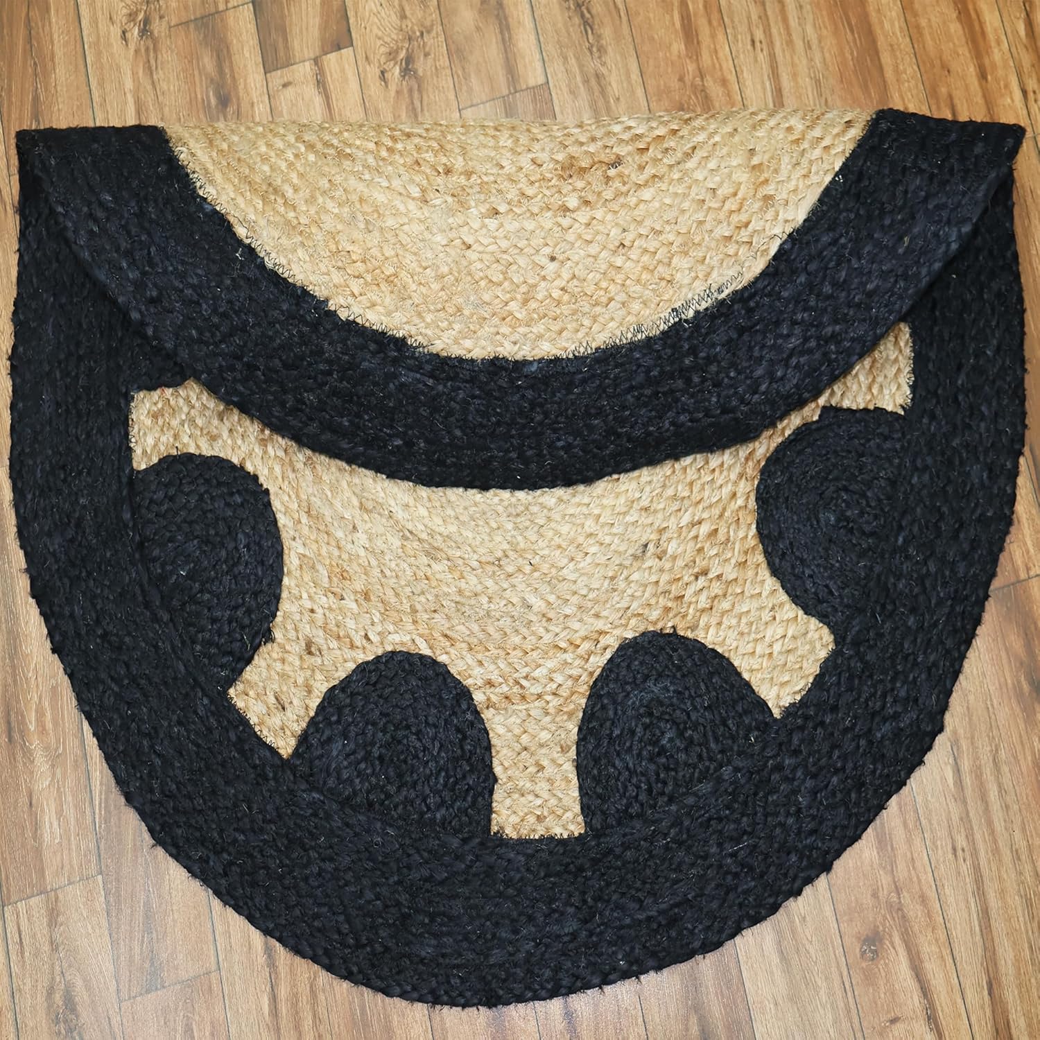 Black and beige half-circle rug on a wooden floor