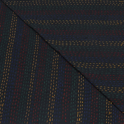 Close-up of dark fabric with multicolored stitching