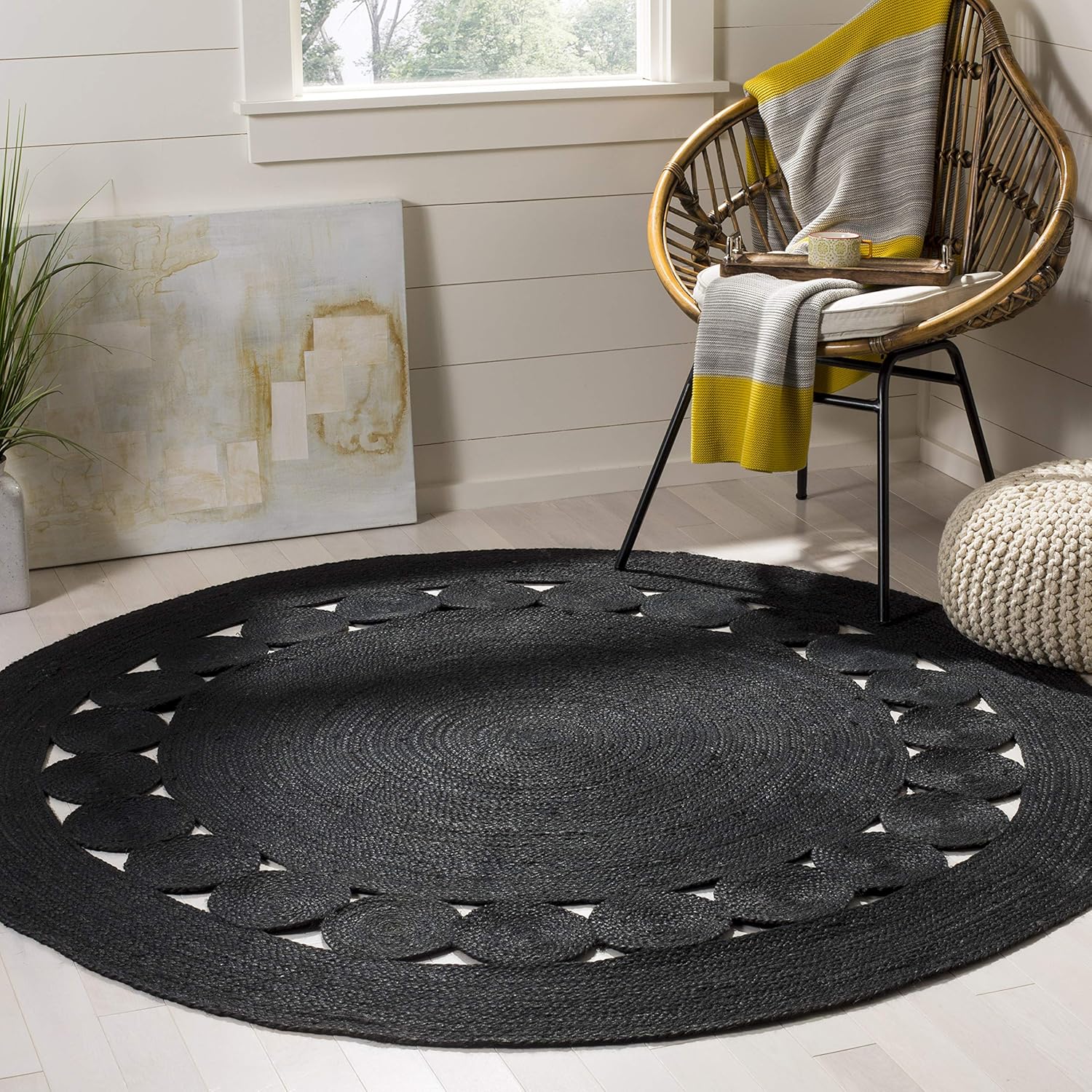 Black round braided rug with circular pattern, perfect for modern home decor.