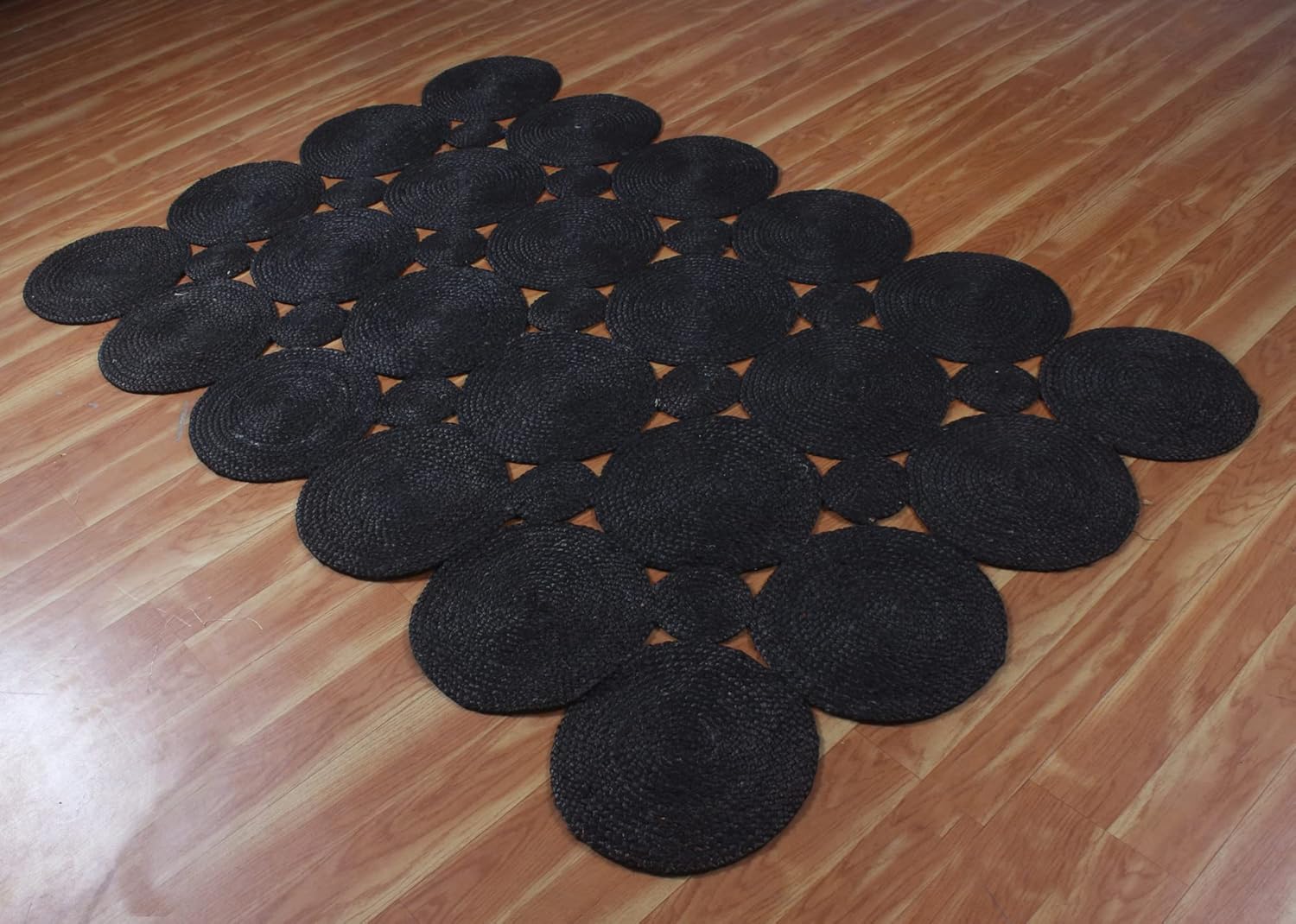 Black round braided rug made of natural fibers, ideal for modern home decor.